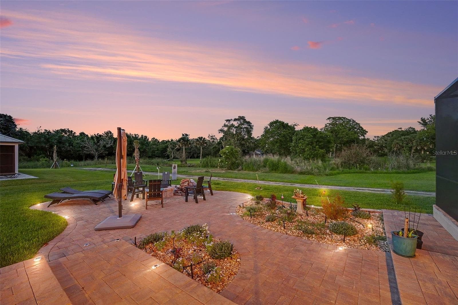 Side yard with fire pit and paved area - 2179 ARNOLD PALMER DR, TITUSVILLE