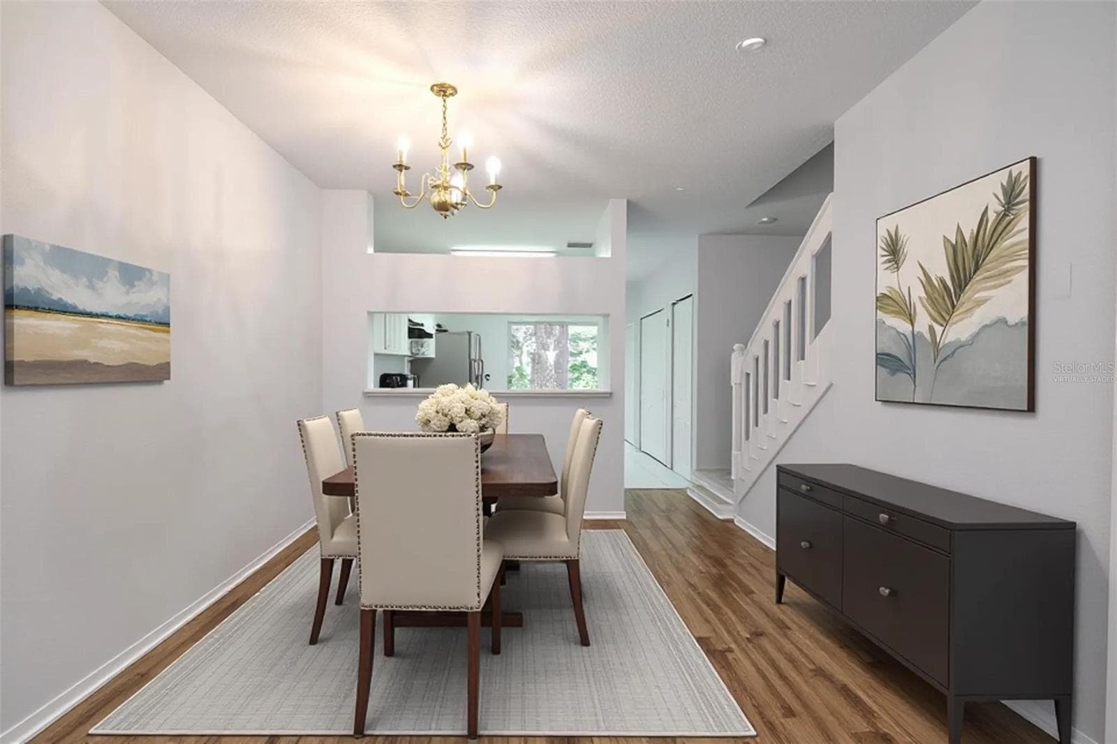 Dining room features wood laminate flooring, a 6 light chandelier and a convenient pass thru to the kitchen. (Photo has been virtually staged.) - 2432 LAKE WOODBERRY CIR, BRANDON