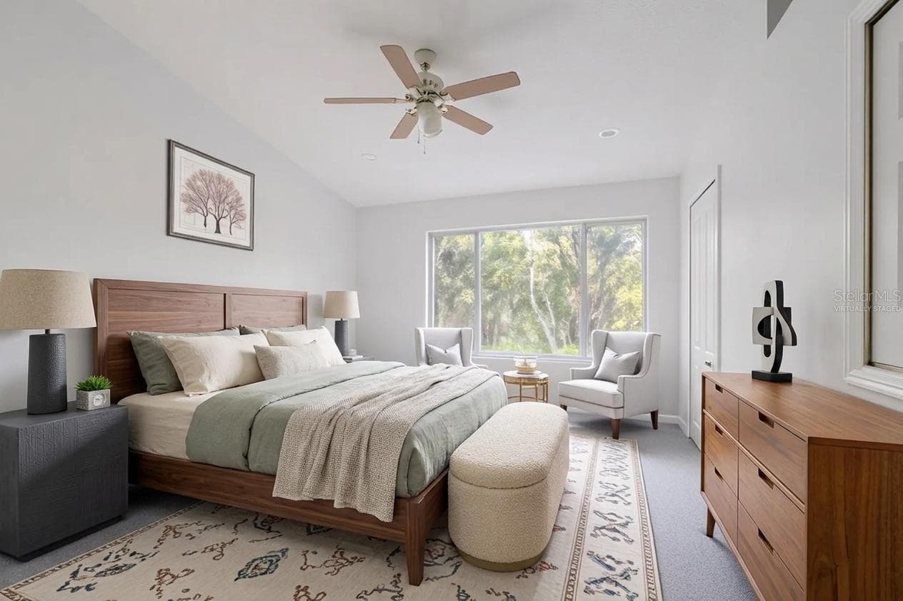 The Primary bedroom features neutral tone walls and carpet, a ceiling fan with light kit and vaulted ceiling. (Photo has been virtually staged.) - 2432 LAKE WOODBERRY CIR, BRANDON