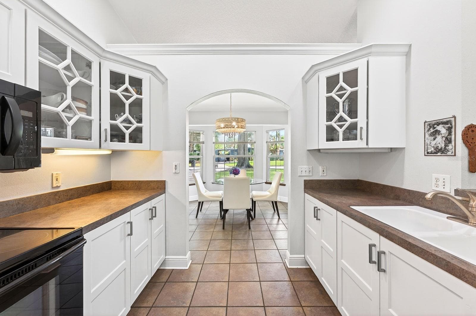 The Kitchen showcases BEAUTIFULLY UPDATED SOLID WOOD WHITE CABINETRY, including select glass-front display cabinets. - 2706 HARGILL DR, ORLANDO