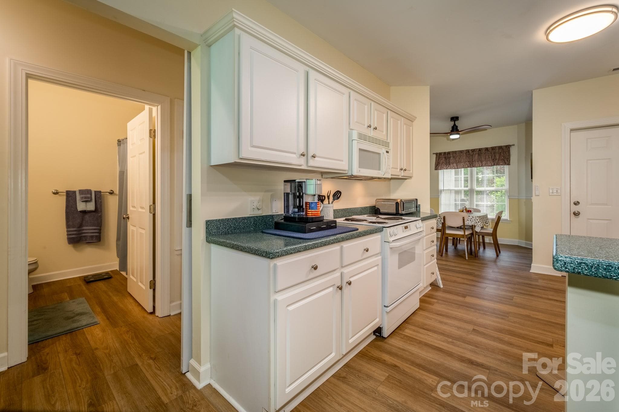 Kitchen & Dining Area – Functional kitchen with abundant cabinetry, ample countertop space, and adjacent dining area for everyday convenience. - 99 Ridgetop Circle, Brevard