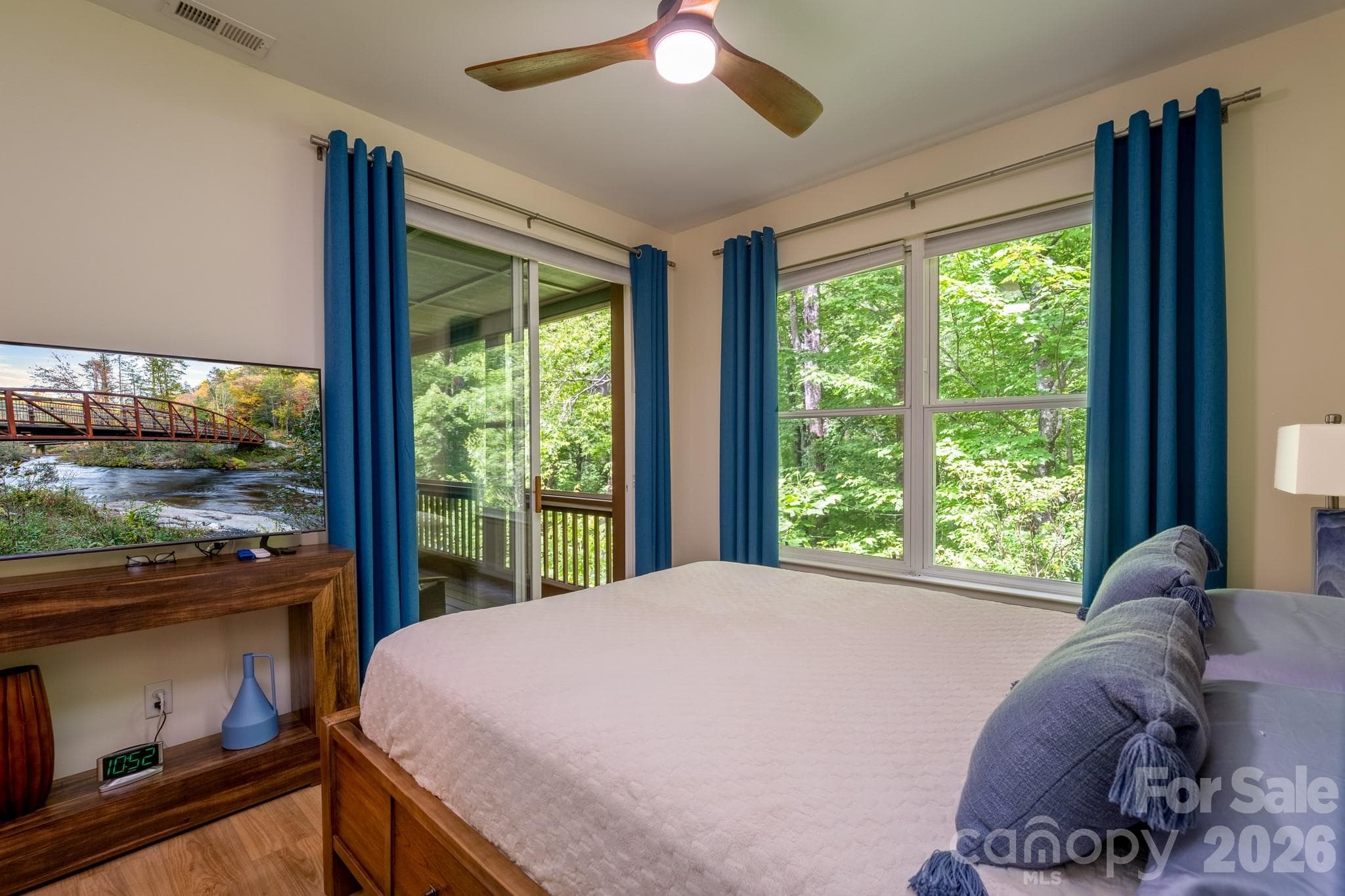 Guest Bedroom with Private Screened Porch Access – Comfortable secondary bedroom offering sliding door access to the screened porch, abundant natural light, and a relaxing connection to nature. - 99 Ridgetop Circle, Brevard