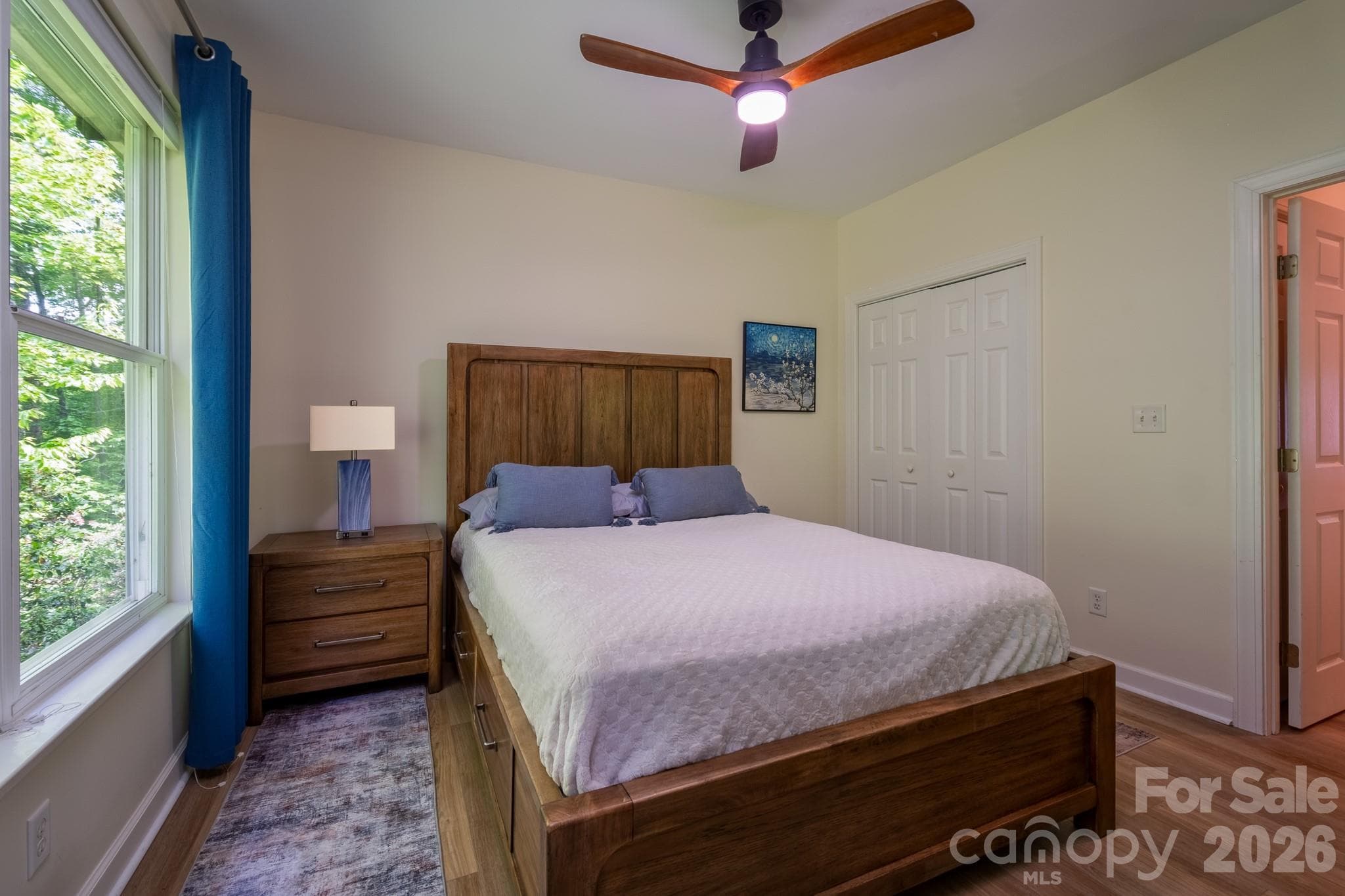 Bright & Inviting Guest Bedroom – Well-appointed guest bedroom with oversized windows, tranquil wooded views, and ample space for guests or flexible use as a den or office. - 99 Ridgetop Circle, Brevard