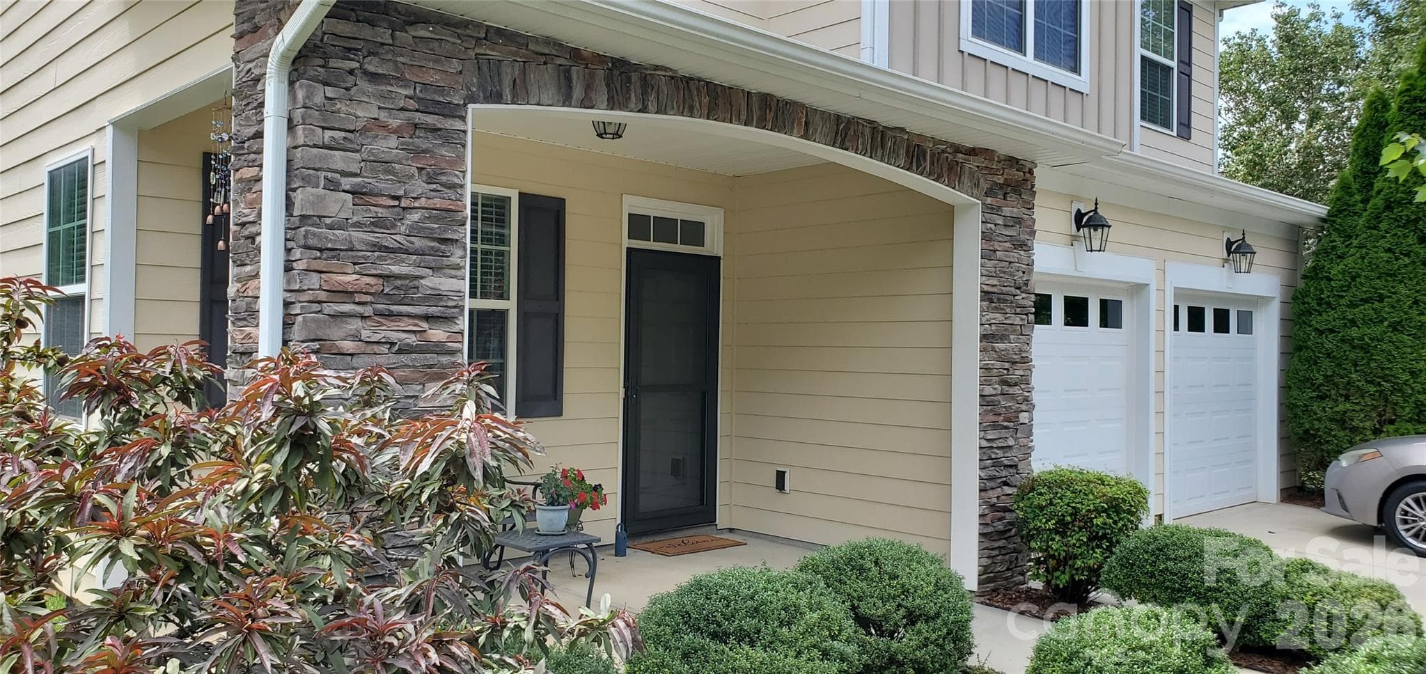 Relax and enjoy the neighborhood from the charming covered front porch with stone detailing and landscaped surroundings. - Mooresville