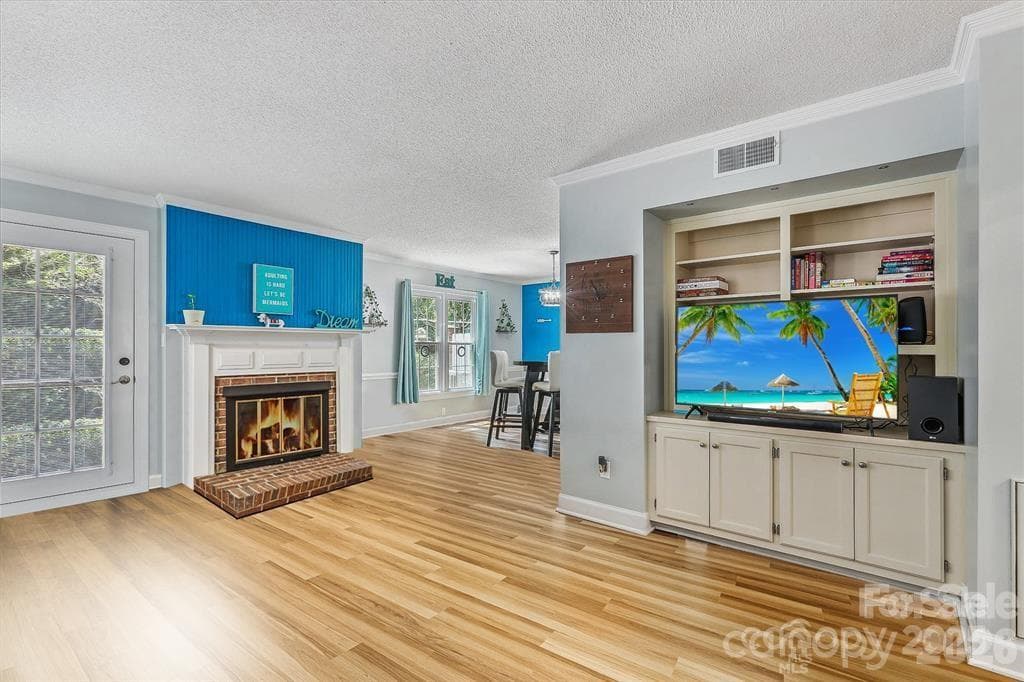 Warm and inviting living room featuring a cozy fireplace, custom built-in shelving, and plenty of space to relax or entertain. Natural light and timeless details create the perfect gathering place to call home - Monroe