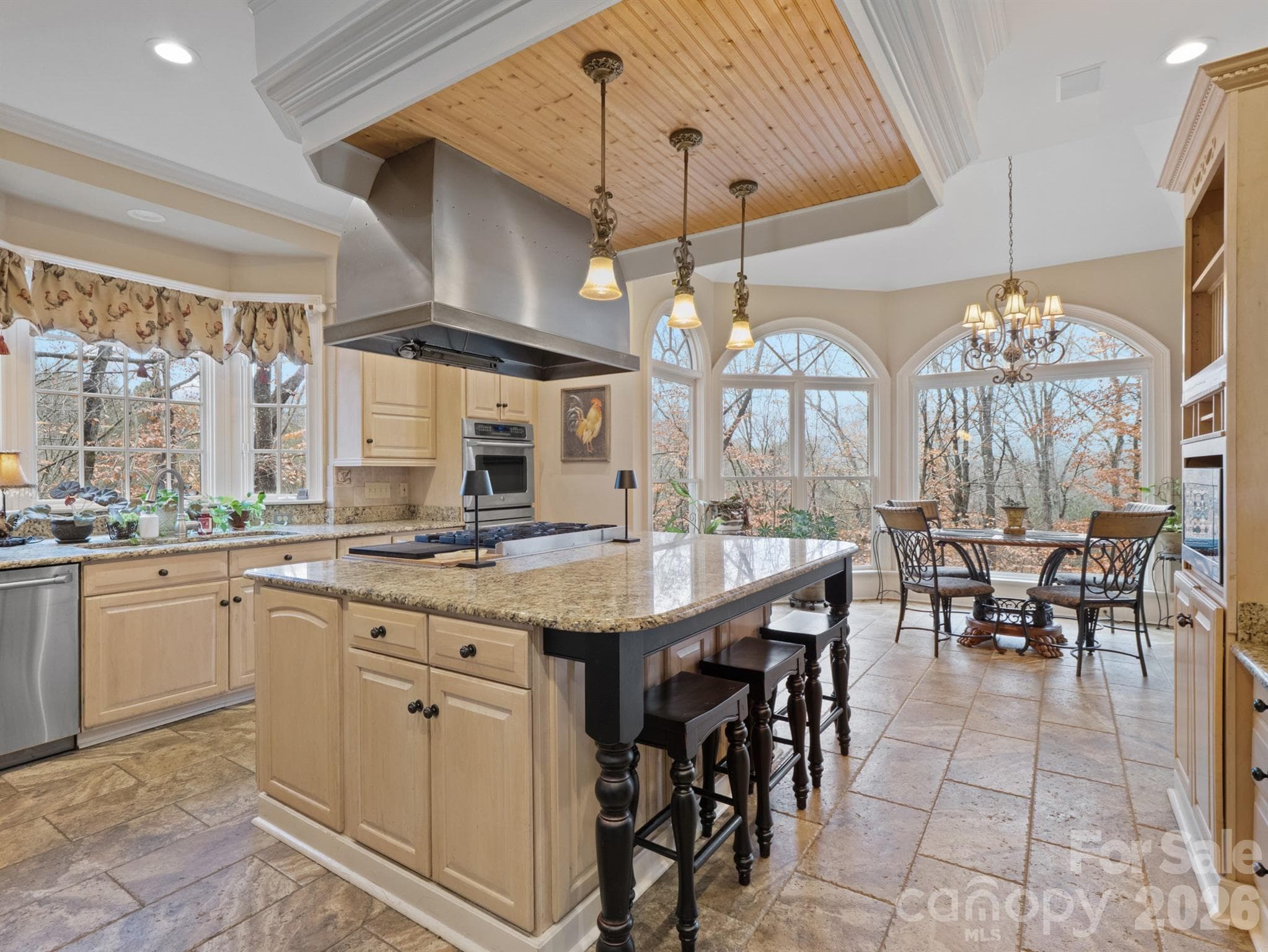 The kitchen offers an inviting center island equipped with a gas cooktop and pendant lights, along with wall ovens and ample cabinet space. - 1090 N Saunders Drive, Catawba