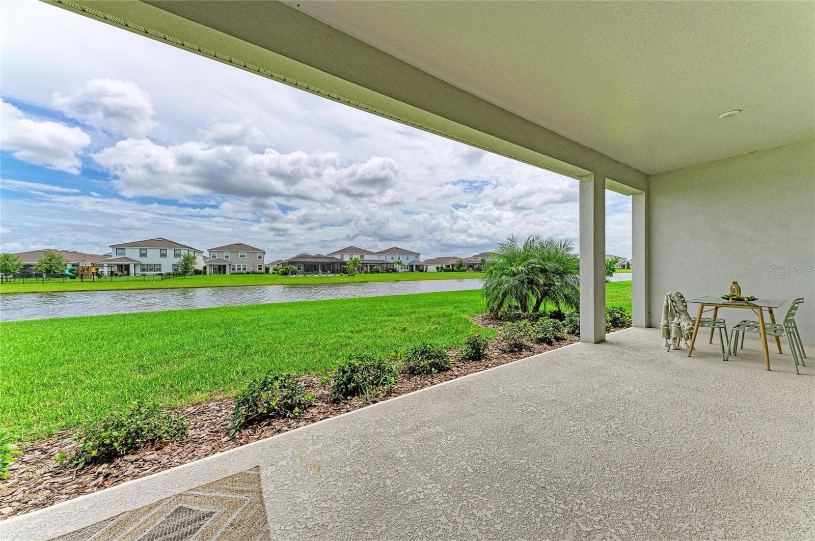 Beautiful rear elevation showcasing seamless indoor-outdoor living and waterfront setting - 17725 ROOST PL, LAKEWOOD RANCH