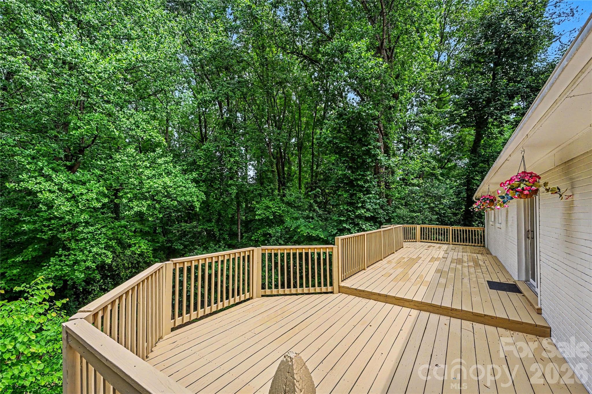 Enjoy peaceful wooded views from this oversized deck designed for gathering with family and friends. - Concord