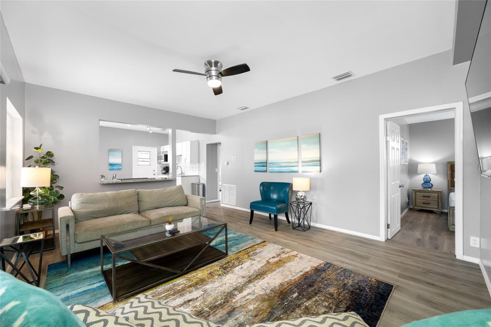 Living Room with electric fireplace and sliding door to the front screened porch - 5044 BETTY ST N, ST PETERSBURG