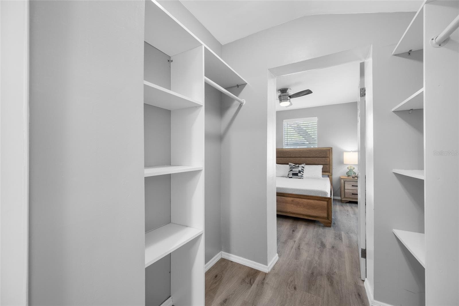 Primary Bedroom suite with walk-in closet, with built in shevles, that opens through to private en-suite updated bathroom with marble tile and glass shower. - 5044 BETTY ST N, ST PETERSBURG