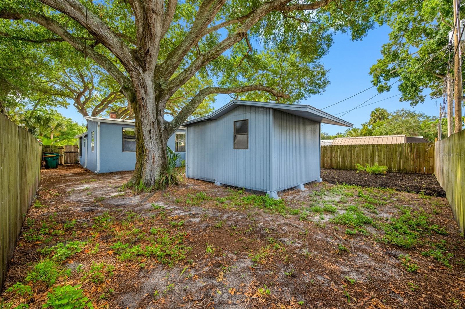 Fenced in back yard with 20ft wide deck that leads to detached workshop and shed. - 5044 BETTY ST N, ST PETERSBURG