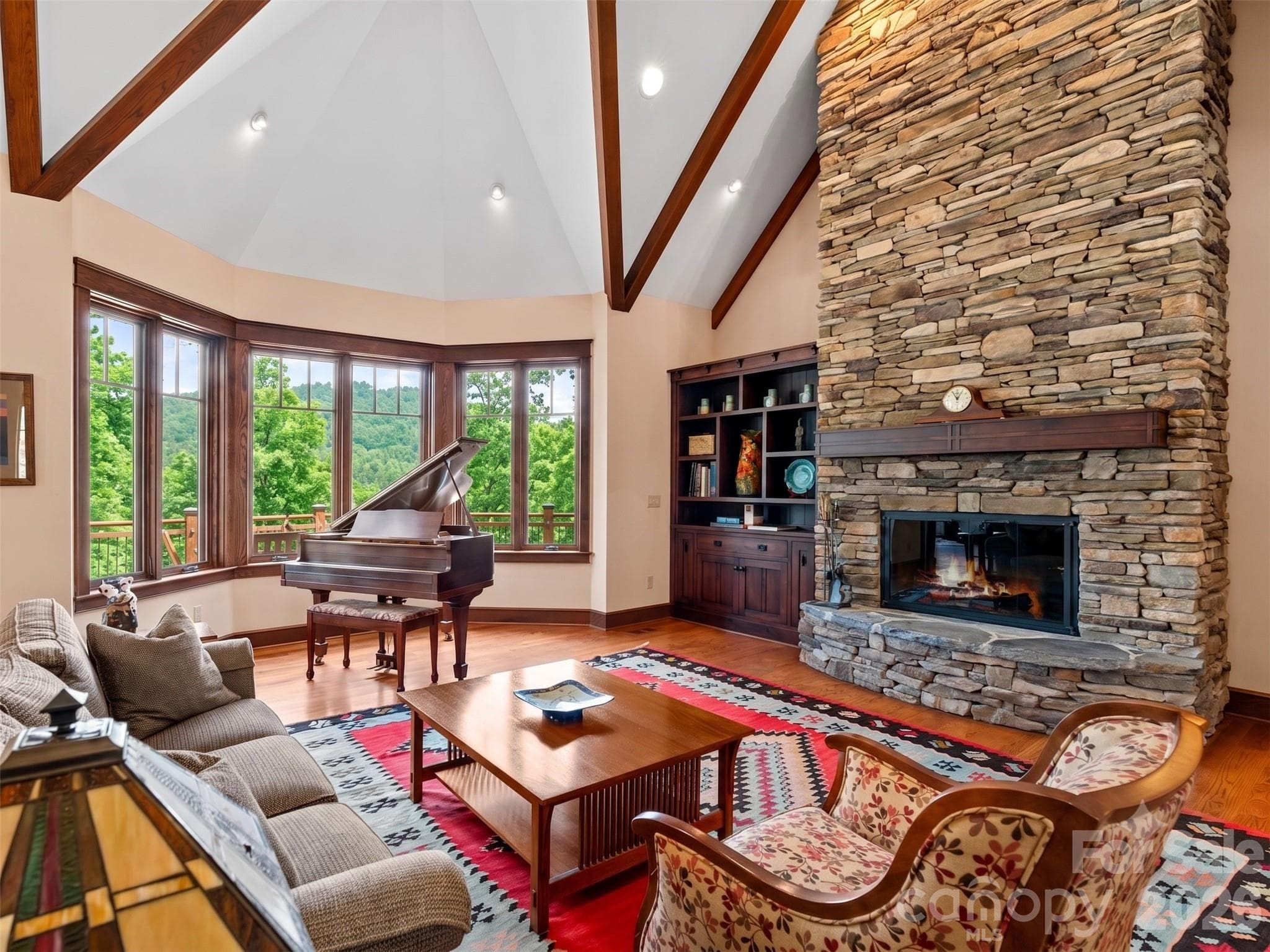 Large family room with stone wood burning fireplace, Oak hardwoods, custom wood trim, vaulted ceilings and large windows with mountain views. - Hendersonville