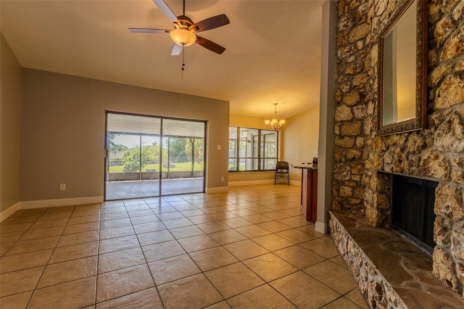 Family room and stone fireplace with sliders out to patio, breakfast nook to right - 1861 CROWLEY CIR E, LONGWOOD