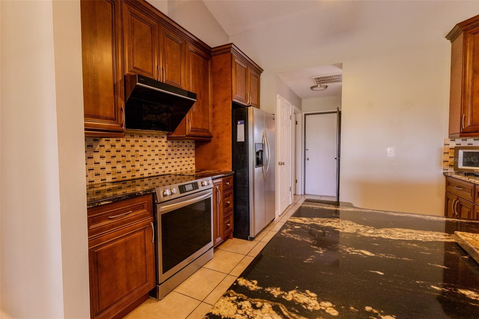Kitchen with wood cabinets and newer appliances as well as granite countertops - 1861 CROWLEY CIR E, LONGWOOD
