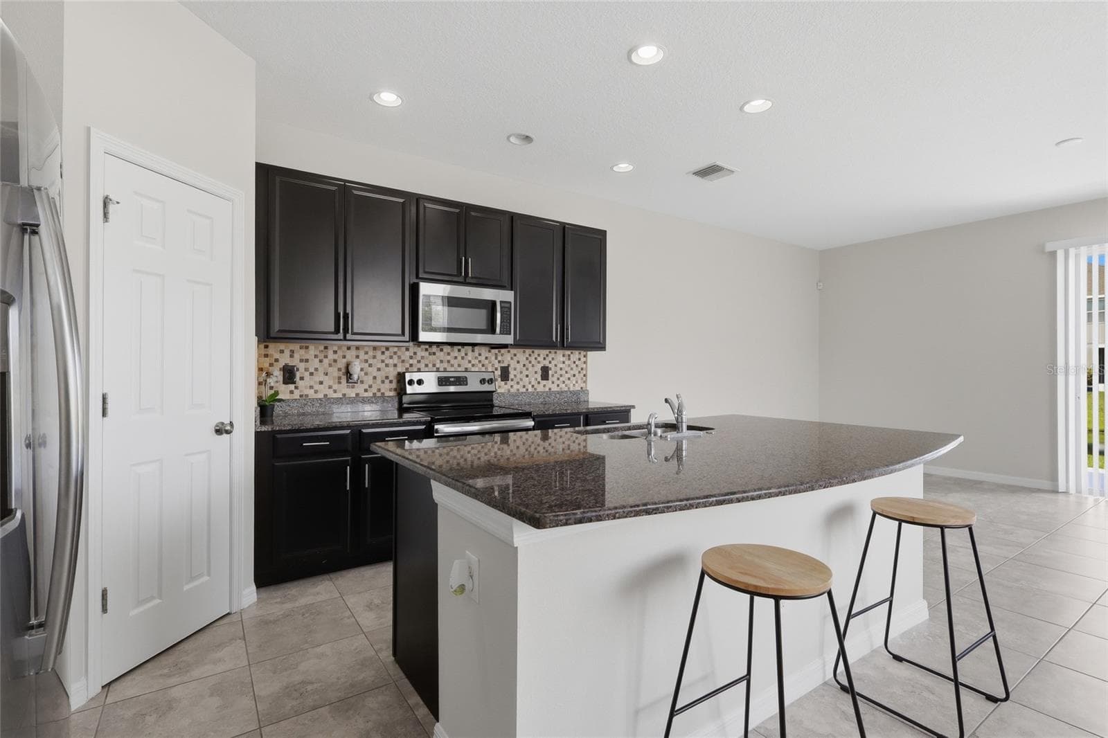 Additional kitchen view showcasing stainless steel appliances and tile backsplash - 7005 GRAND ELM DR, RIVERVIEW