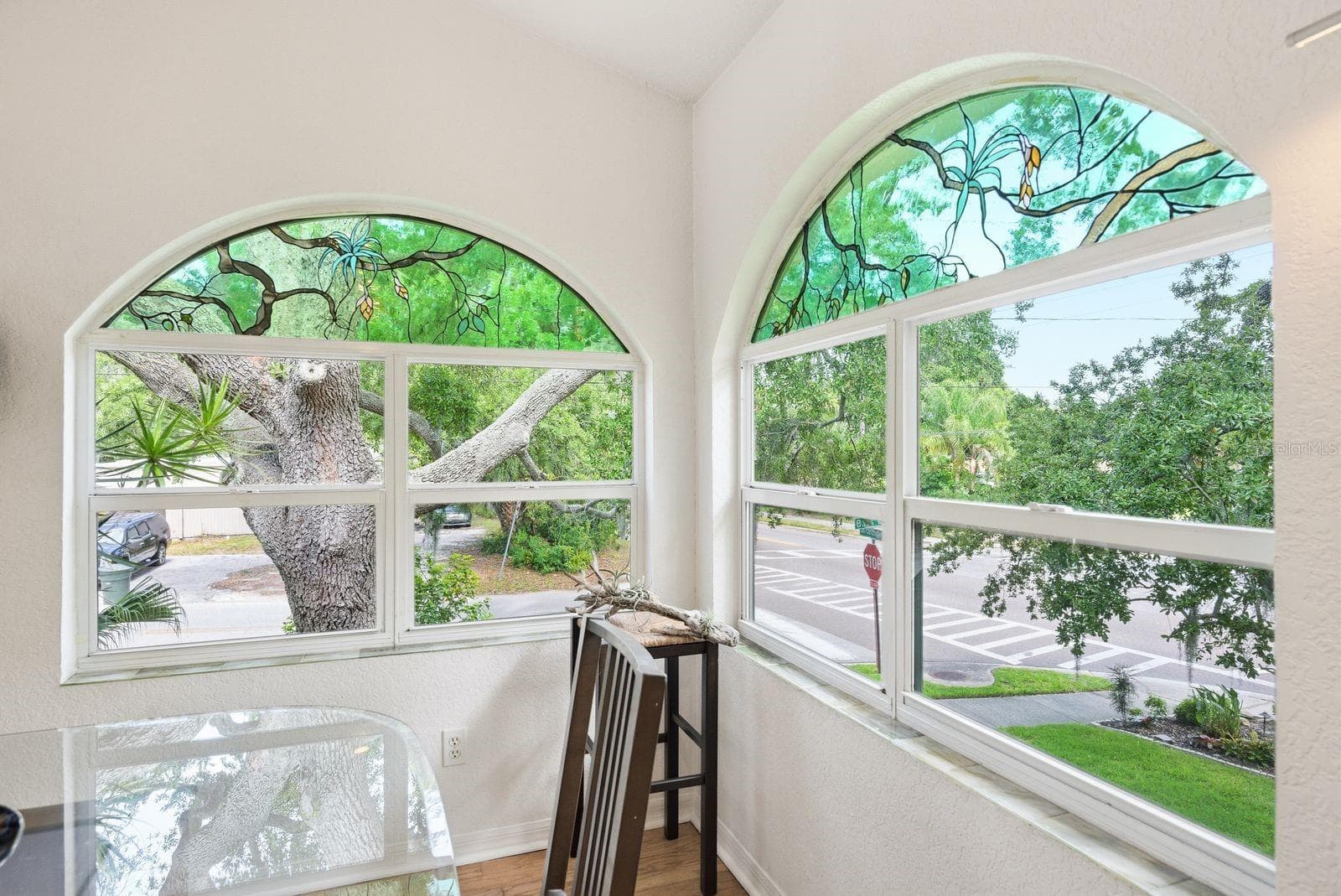 Dining Room custom stained glass created to mimic the oak tree coming in from the outside and windowsills lined with custom handmade fused glass tiles. - 755 SAN CHRISTOPHER DR, DUNEDIN