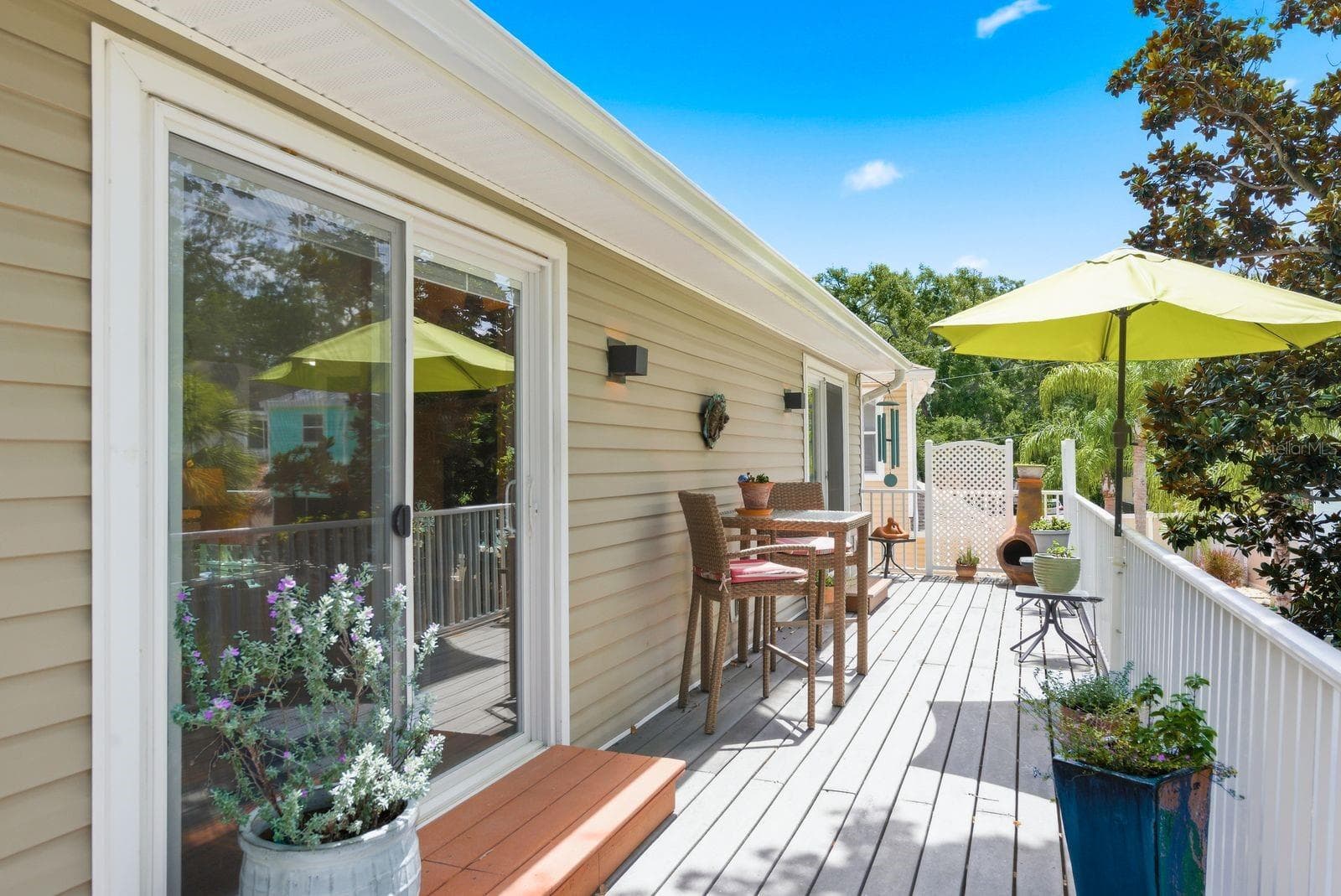Living room and Primary Bedroom sliders lead to upstairs Trex deck overlooking landscaped backyard. - 755 SAN CHRISTOPHER DR, DUNEDIN