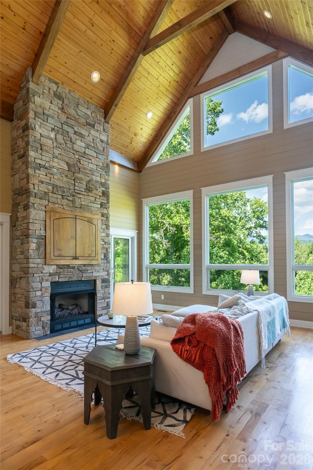 Vaulted Great Room serves as the centerpiece w/ expansive windows framing the mountain views along with the grounding stacked stone fireplace - 33 Bridle Path Drive, Barnardsville
