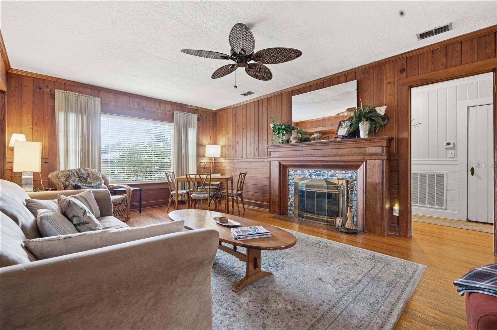 Spacious living room with classic stone fireplace and bright, welcoming layout. - 411 W 48TH ST, BRADENTON