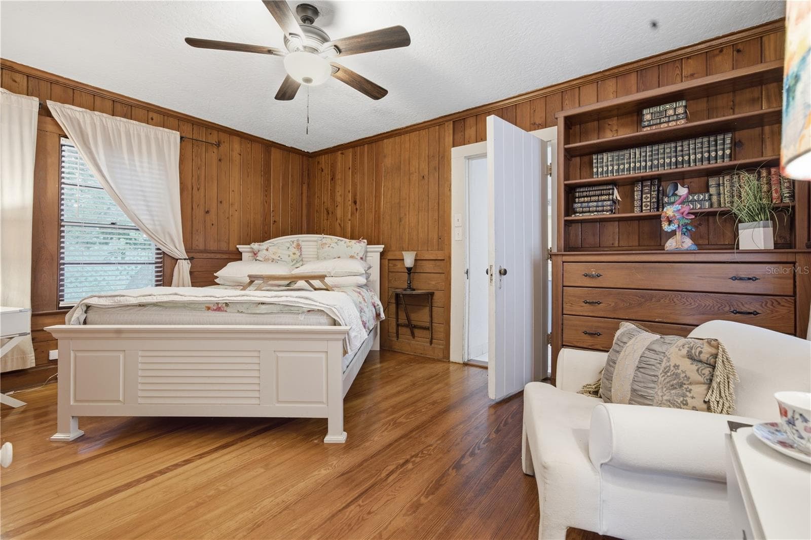 Comfortable primary bedroom with updated flooring and peaceful views. - 411 W 48TH ST, BRADENTON
