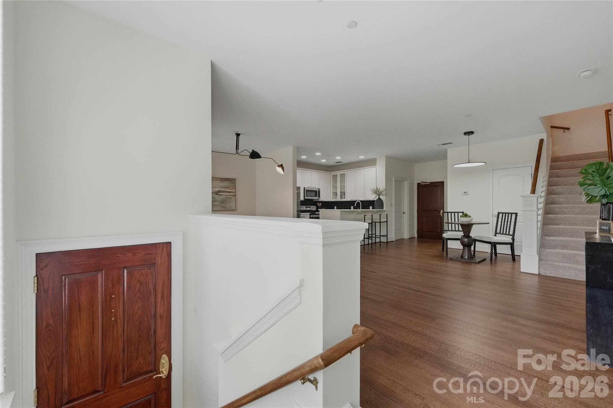 A warm welcome home as you step through the rich wood front door and into a wide-open living space flooded with light, designer fixtures, and gorgeous hardwood floors. - Charlotte