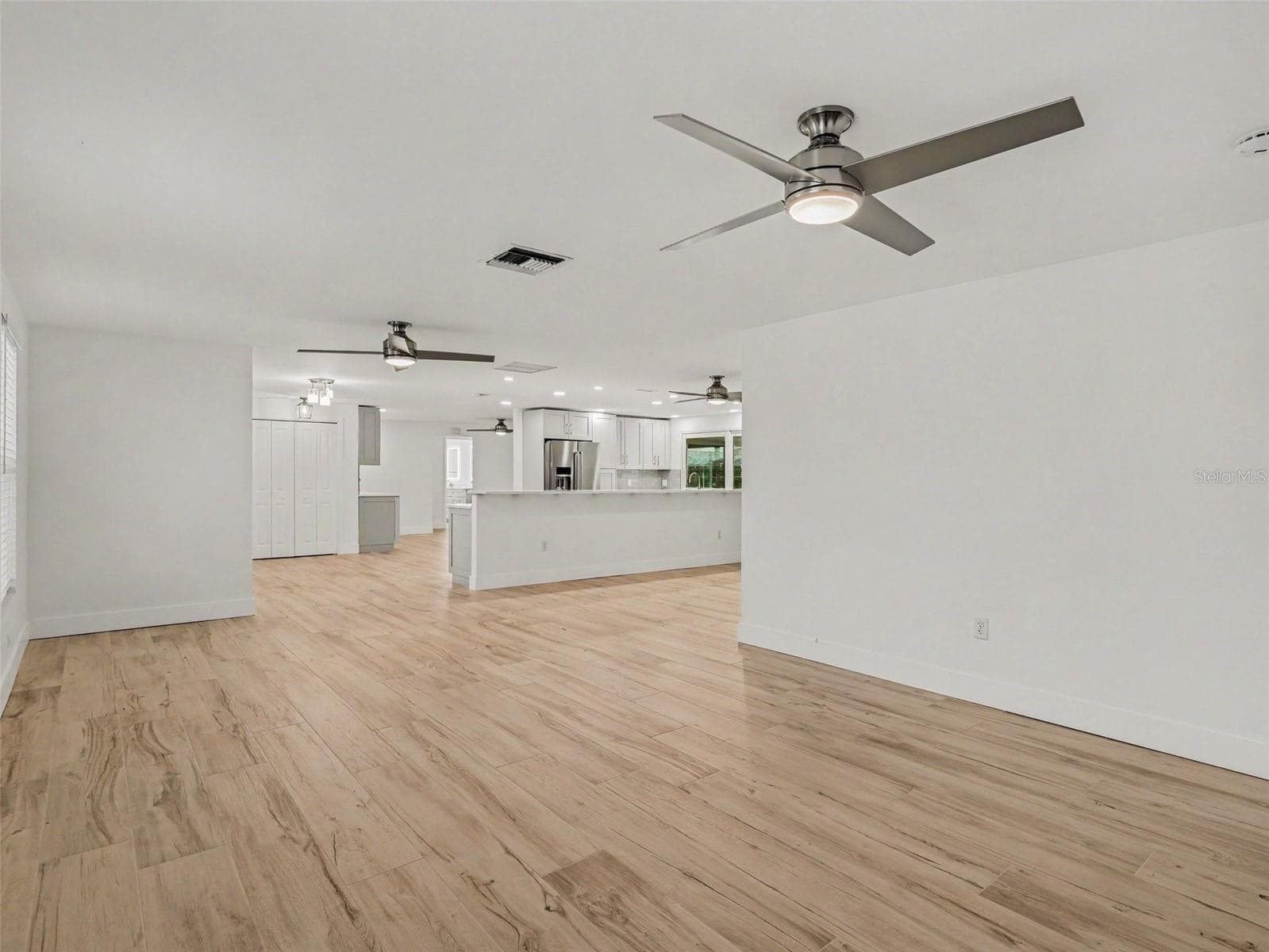 Living room looking into the foyer, family room and kitchen - 548 BELVEDERE CT, PUNTA GORDA