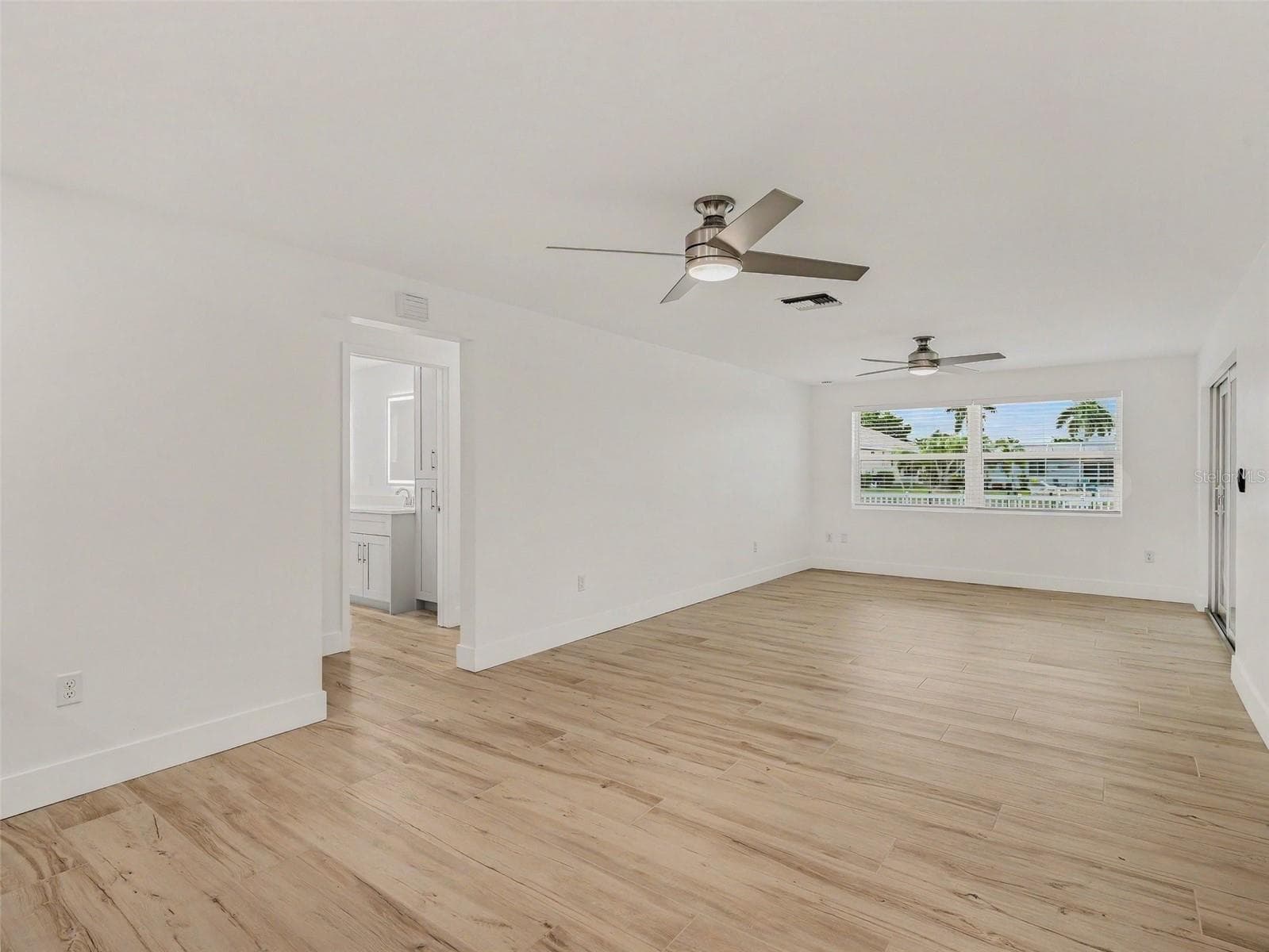 Family room looking toward back yard/pool from wet bar area - 548 BELVEDERE CT, PUNTA GORDA