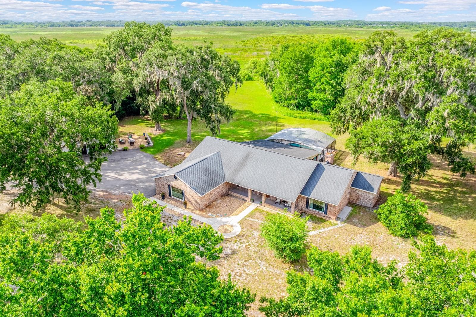 Peaceful, private, and packed with possibilities, this beautifully updated POOL HOME sits on TWO PARCELS totaling 5 ACRES with a PRIVATE GATED ENTRANCE, a 3/4 ACRE POND WITH DOCK, and beautiful views of Lake Runnymede! - 1600 E 10TH ST, ST CLOUD