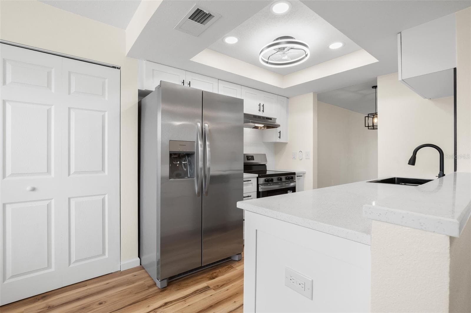 Gorgeous new lighting and overhead fan. Pantry space with shelves to the left of fridge. Washer and dryer connections are in-suite, in the utility room, see photo #25 - 5817 PARK ST N #302, ST PETERSBURG
