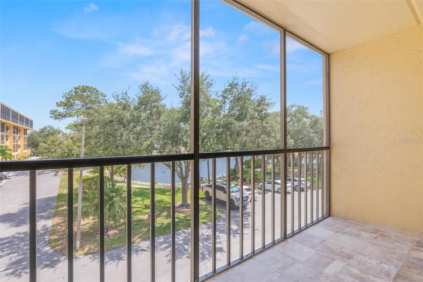 Spacious screened balcony with a view of the pond. - 5817 PARK ST N #302, ST PETERSBURG