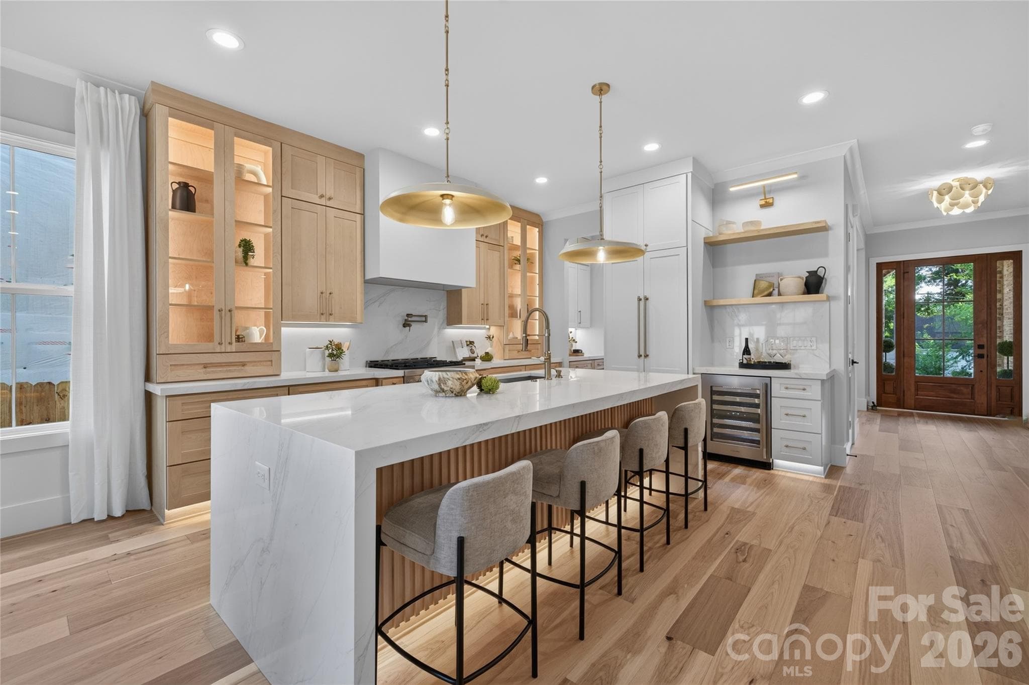 Gourmet kitchen with all the bells and whistles! Interior cabinet lighting, dimmable toe kick & under cabinet lighting, panel ready refrigerator, beautifully appointed maple & off white two toned cabinetry, 2.5" Calcutta Silverlight countertop with waterfall edge and Calcutta Quartz backsplash. - Charlotte