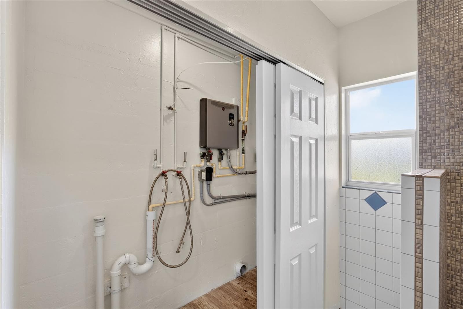 Laundry closet in bathroom. Also holds tankless hot water heater and new electrical panel - 10451 MARION ST, ENGLEWOOD