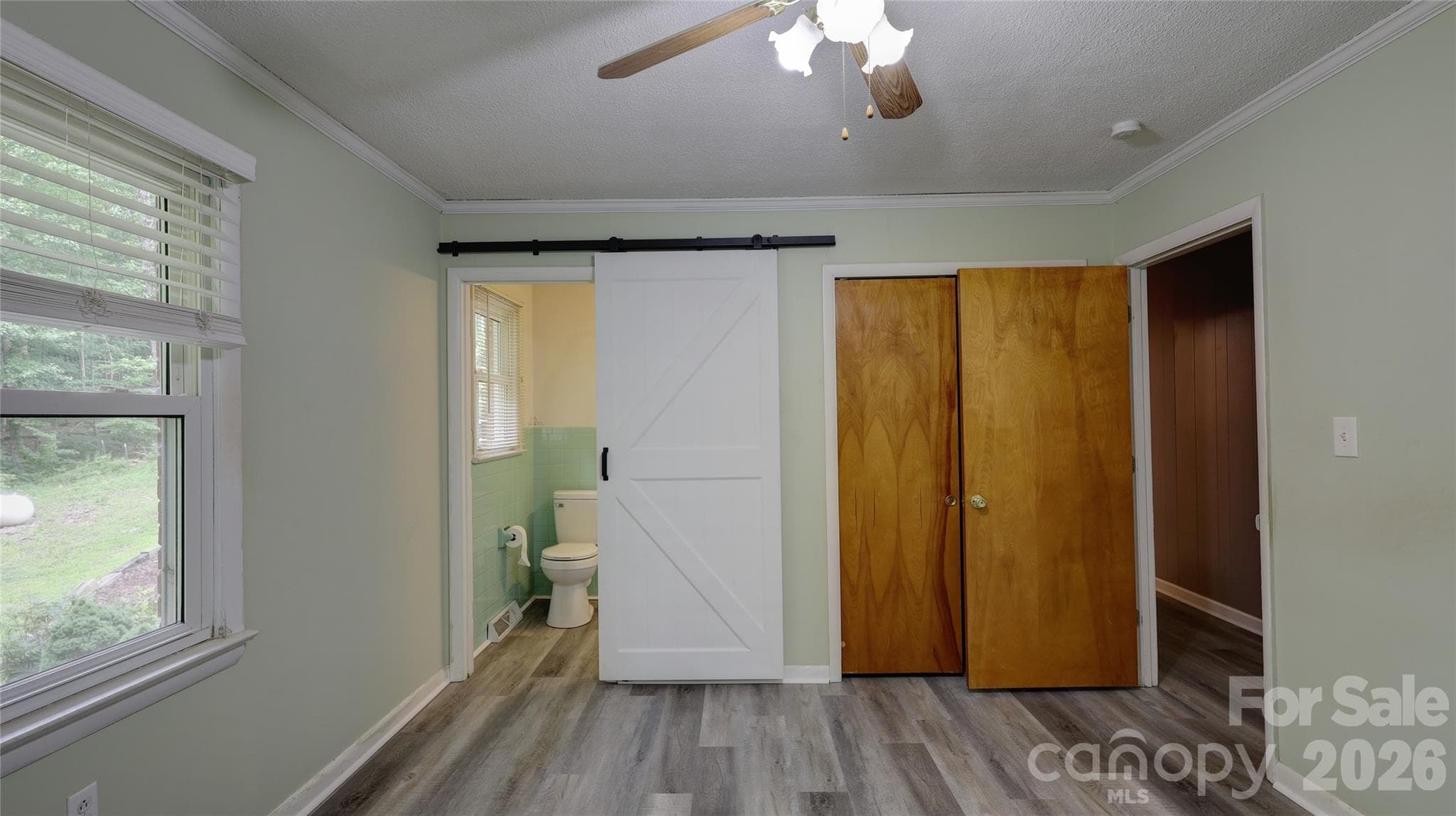 Primary Bedroom with new LVP flooring with ensuite 1/2 bath with modern barn door. - 1130 Allman Extension, Mount Pleasant