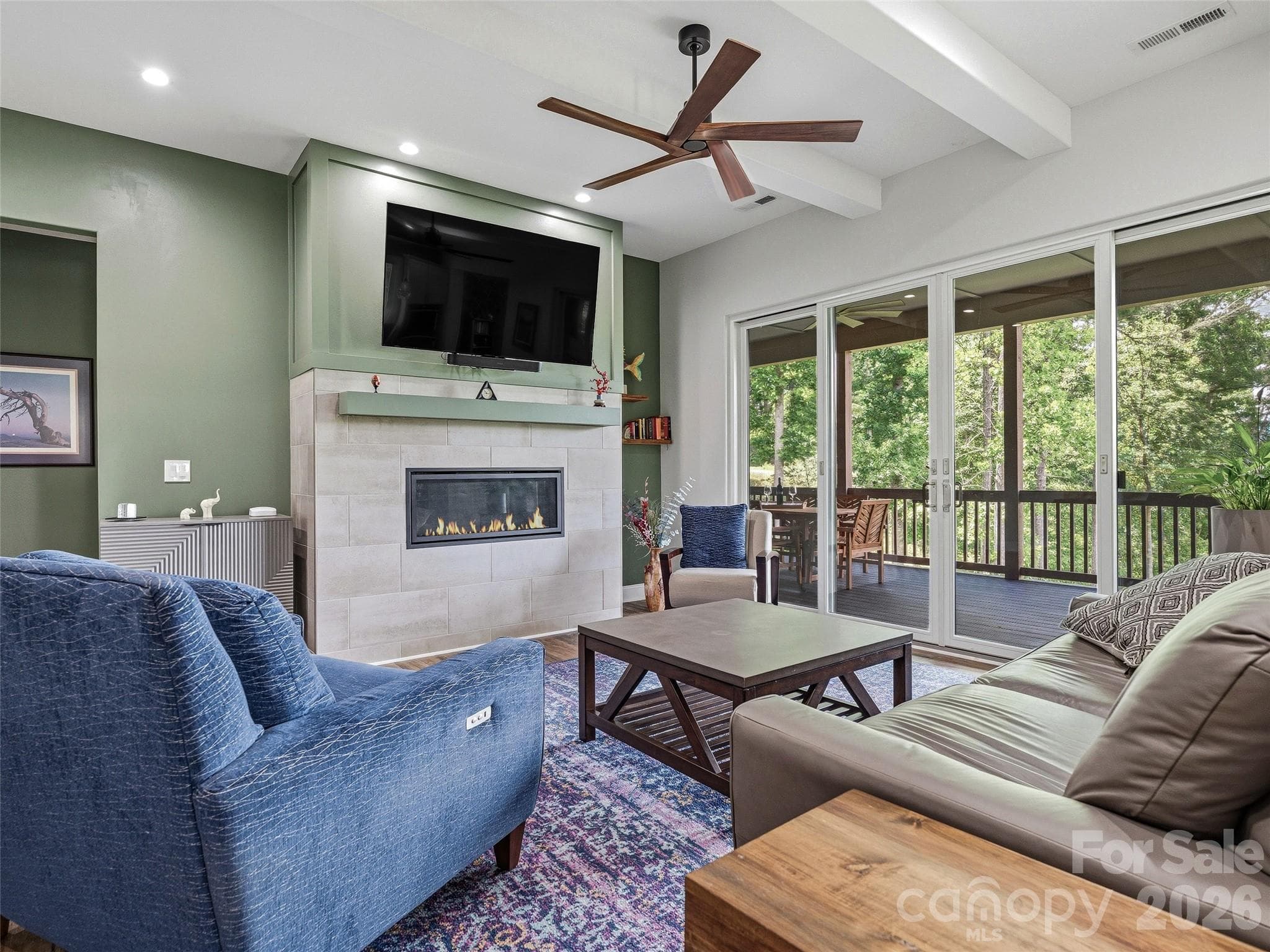 Expansive glass doors flood the living room with natural light while framing breathtaking mountain views. - 11 Timber Hill Drive, Leicester