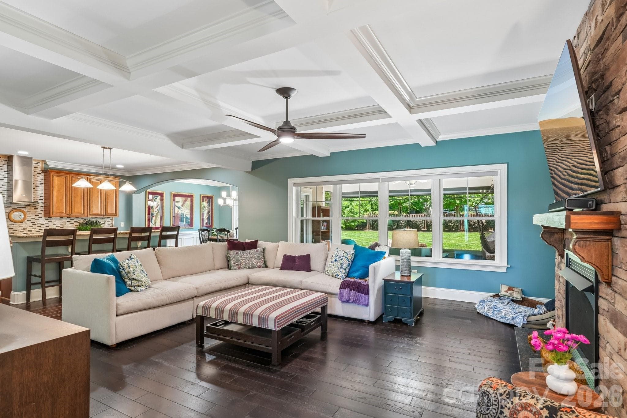 The open-concept great room features coffered ceilings, - Charlotte