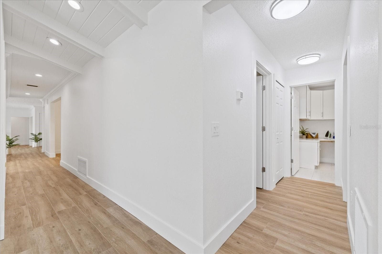 Looking from side entry to hallway towards kitchen and on right guest bathroom, bedroom and laundry room. - 5623 HULL CT, NEW PORT RICHEY