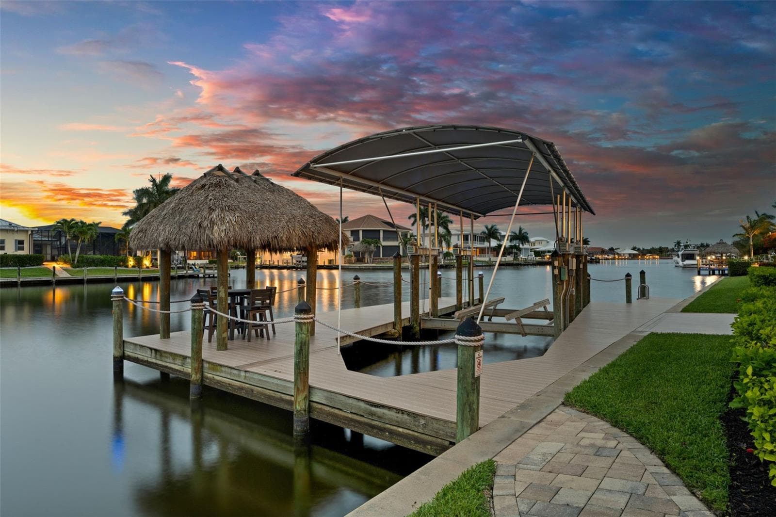 Dock, lift and canal in the evening - 105 SW 52ND ST, CAPE CORAL