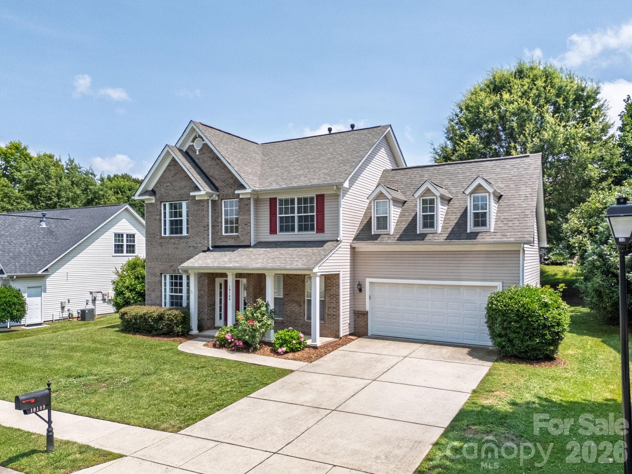 Well-maintained exterior with spacious driveway and two-car garage. - Charlotte
