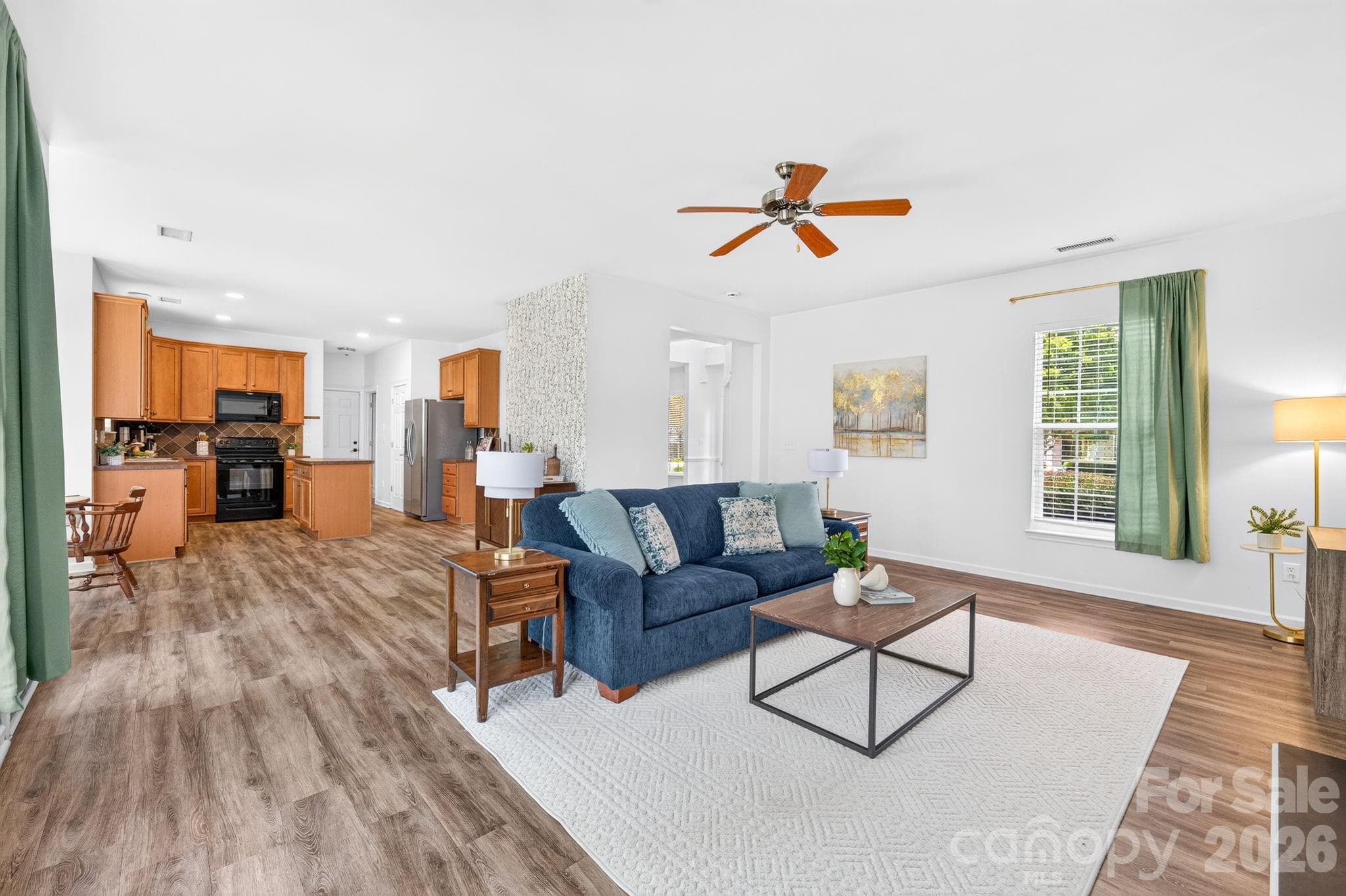 Bright, open living room featuring durable LVP flooring and abundant natural light. - Charlotte