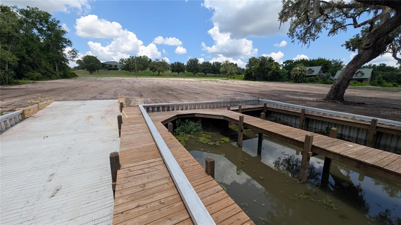 View of ramp, boat dock, and cleared property from canal side - SULEN RD, LADY LAKE