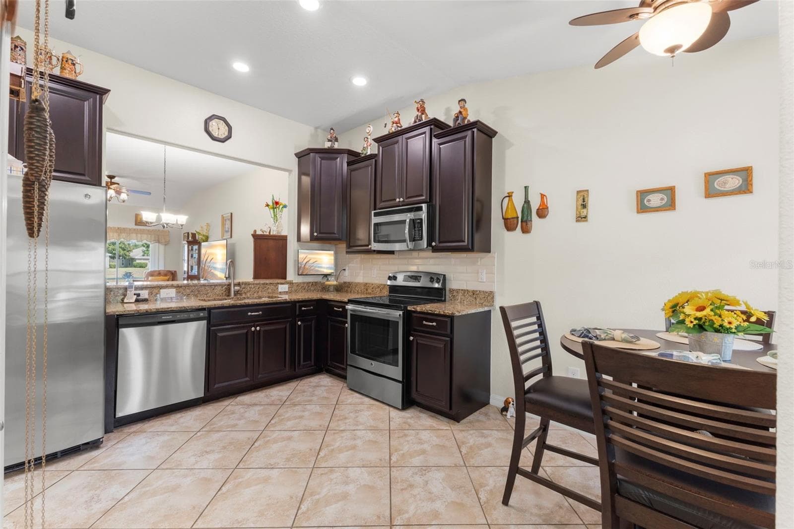 Kitchen with dark wood cabinetry, Stainless Steel appliances and granite counters - 13627 CREST LAKE DR, HUDSON
