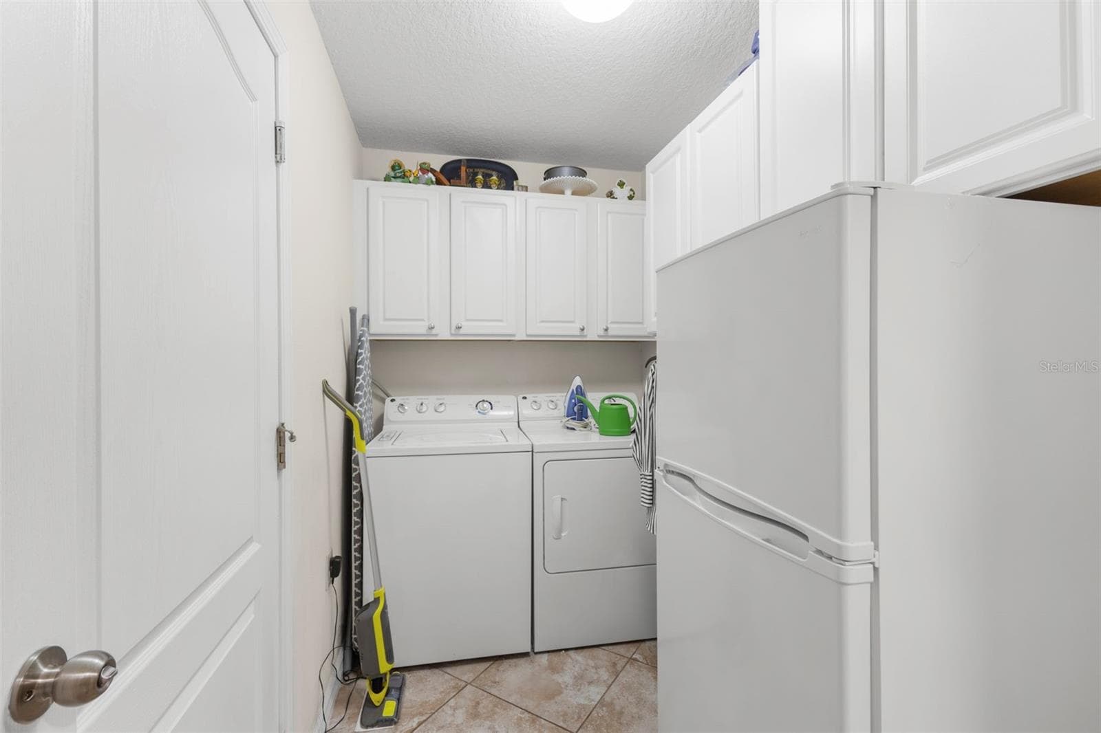 Laundry room with bonus refrigerator/freezer and cabinets for storage - 13627 CREST LAKE DR, HUDSON