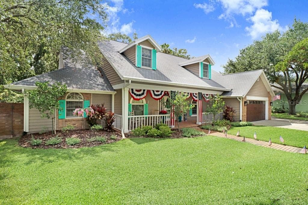 Well-manicured landscaped front yard with front porch - 1976 DUNLOE CIR, DUNEDIN