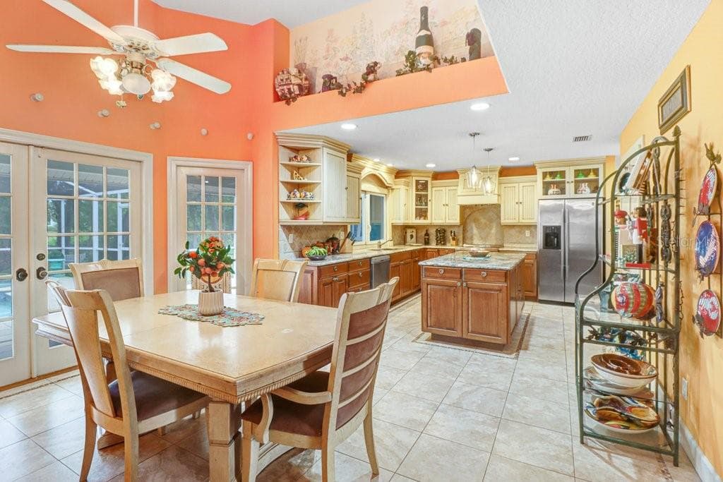 Large Eat-in Kitchen with French doors leading out to pool/patio area with vaulted ceilings. - 1976 DUNLOE CIR, DUNEDIN