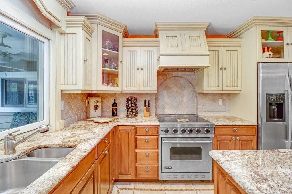 Viking Range and split stainless steel sink and decorative tile backsplash. - 1976 DUNLOE CIR, DUNEDIN