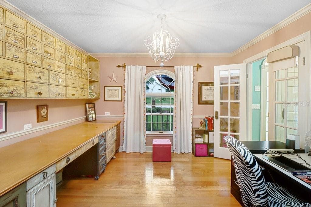 Another view of home office which highlights cabinetry and view out front of house and french doors next to front entry. - 1976 DUNLOE CIR, DUNEDIN