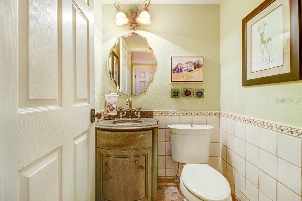 Charming custom 1/2 bath off kitchen with river rock floor tile. - 1976 DUNLOE CIR, DUNEDIN