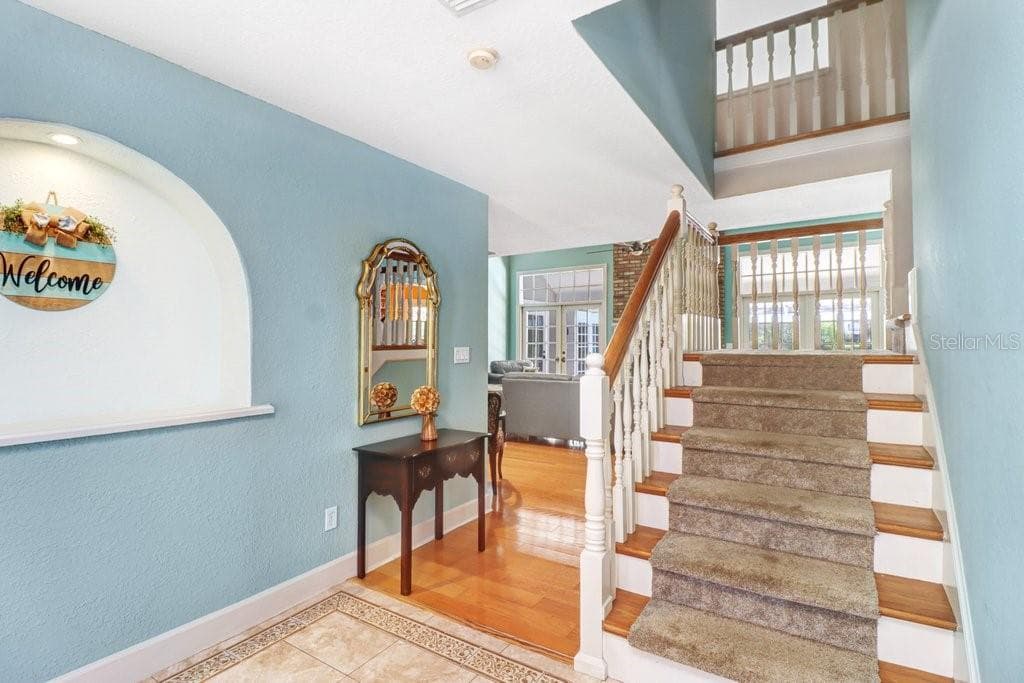Take the stairs up to the 2nd floor to view the 3 bedrooms and bathroom upstairs. - 1976 DUNLOE CIR, DUNEDIN