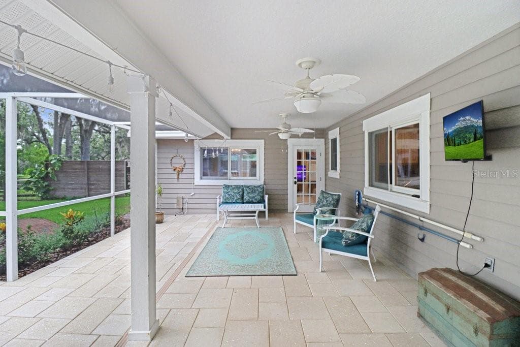 Relaxing patio area under roof with ceiling fans, perfect for parties and barbeques. - 1976 DUNLOE CIR, DUNEDIN