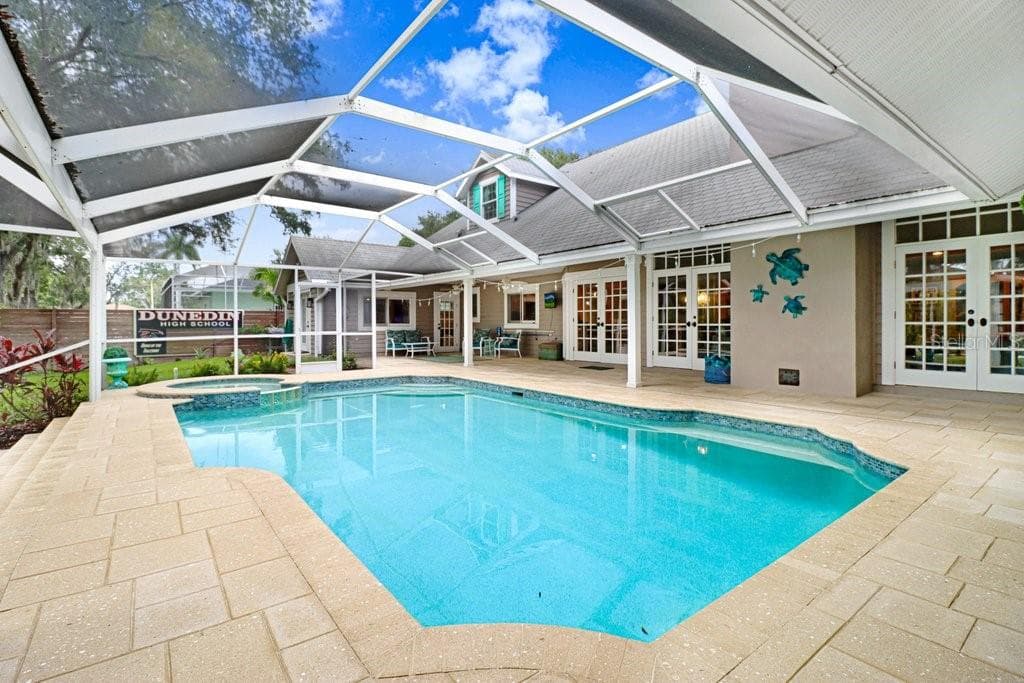 Custom shaped pool with swim seat, spa with spillover ledge feature. - 1976 DUNLOE CIR, DUNEDIN